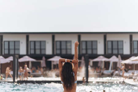 Young woman on the background of the pool in a white swimsuit.の写真素材