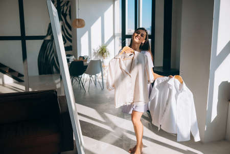 Beautiful girl trying dress in roomの写真素材