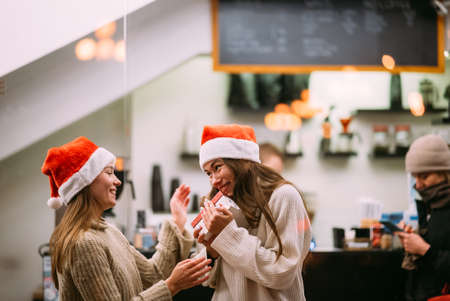 The girl gives a gift to her female friend in caffeの写真素材
