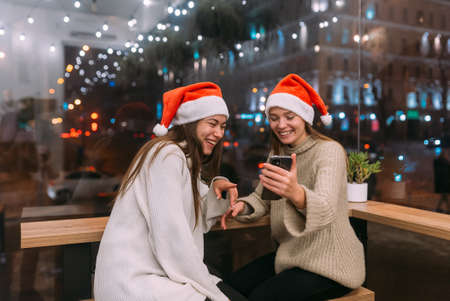 Two young girls using smartphone at the cafe.の写真素材