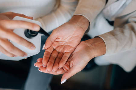 Female hands applying antibacterial liquid soap close up.の写真素材