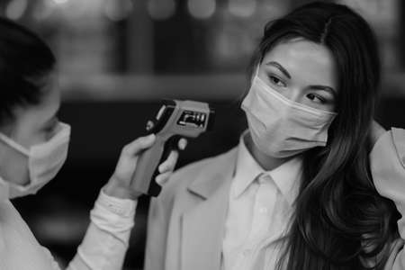 Measuring body temperature with contactless body thermometerの写真素材