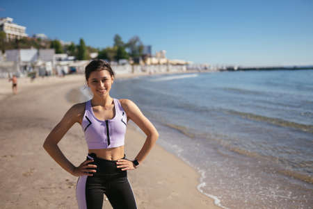 Beautiful woman in a public beach after training with sporty look