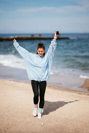 Beautiful woman in a public beach after walk with sporty lookの写真素材