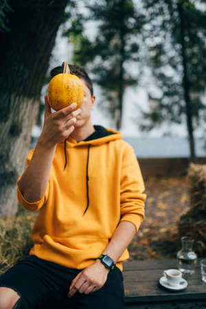 Autumn, harvest and people concept - Man holding small yellow pumpkinの写真素材