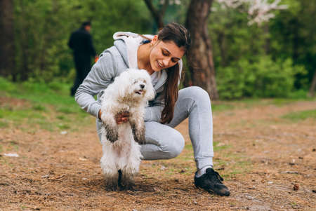 Beautiful woman holding a dog in her armsの写真素材