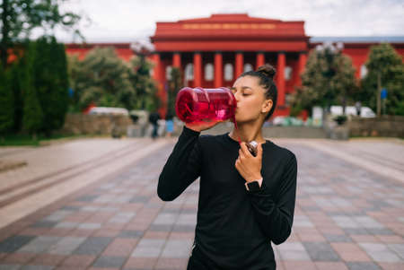 Fitness model in sportswear posing on the city street.