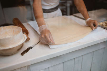 A man prepares an apple strudel for sale. Prepares the doughの写真素材