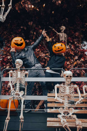 A guy and a girl with a pumpkin heads posing on the streetの写真素材