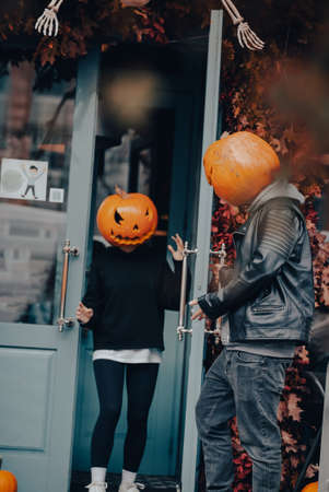 Couple with pumpkin heads posing on camu at the building