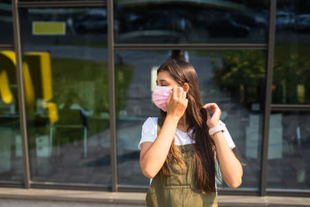 Young woman putting on protective mask for coronavirus prevention.