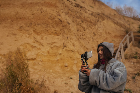 Young woman takes a photo on a smartphone of the seascapeの写真素材