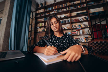 Beautiful business woman writing something in notebook.