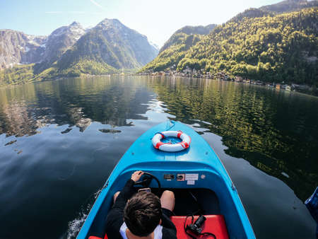 Man controls a motorboat on a mountain lakeの写真素材
