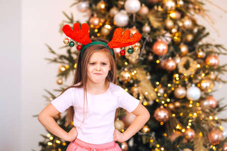 Portrait of little girl wearing deer christmas hat. Winter holidays and people concept.の写真素材