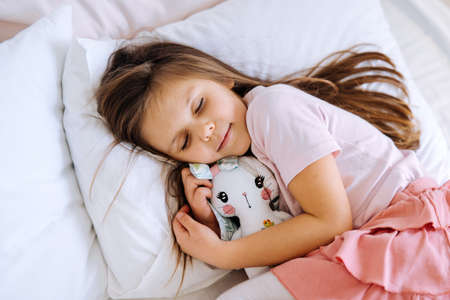 little girl with toy sleeping at home