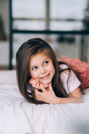 Little girl lying in the bed looking away.の写真素材