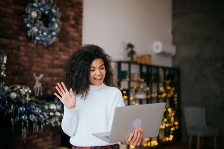 Young happy african woman holding laptop in hands