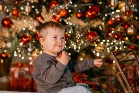 Little boy playing by the christmas treeの写真素材