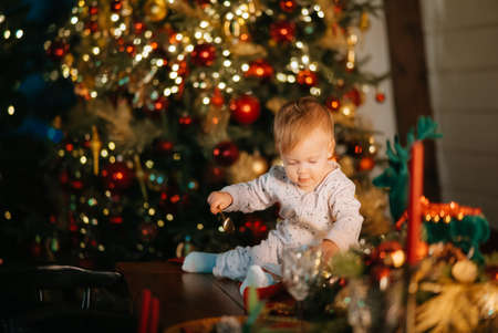 Little boy playing by the christmas treeの写真素材