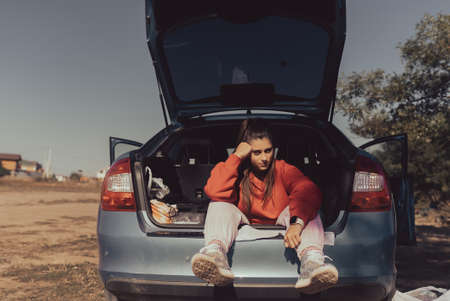 Attractive young woman resting in the trunk of a carの写真素材