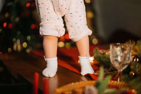 Cute little baby legs in room with Christmas treeの写真素材