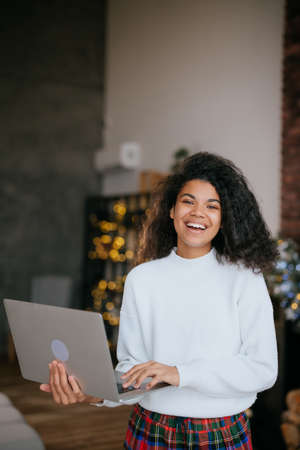 Young happy african woman holding laptop in handsの写真素材
