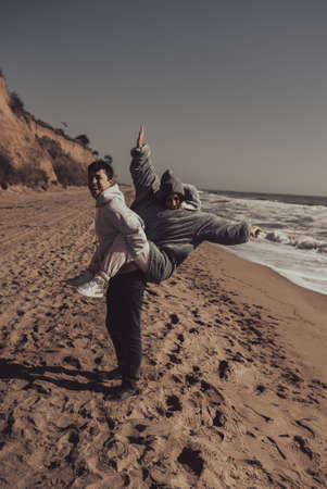 Man carries his girlfriend on back, couple having fun on the seashoreの写真素材