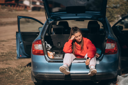 Attractive young woman resting in the trunk of a car