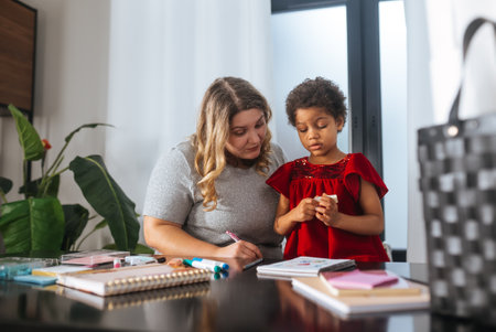 Mother and child daughter draws creatively at the tableの写真素材