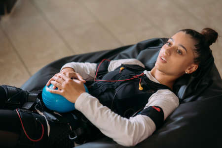 EMS training. The girl lies in a suit with cables.の写真素材