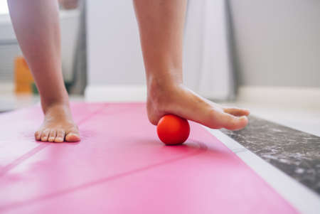 Woman massages the foot with a ball. Close viewの写真素材