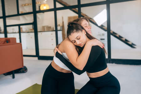 Two girlfriends hug each other after yogaの写真素材