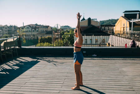 Young woman practicing yoga on the roof of a building