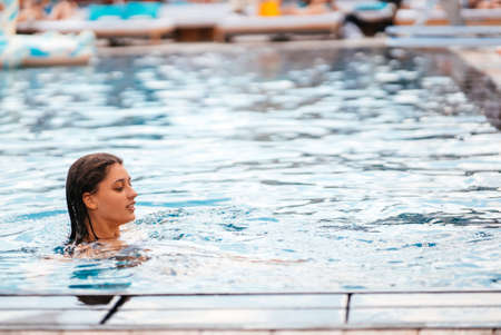 Young woman swimmer in blue pool water