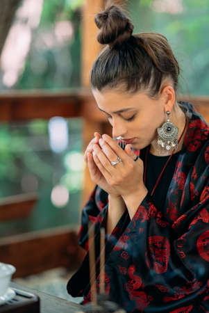 Young woman enjoys the smell of green tea at a tea ceremony