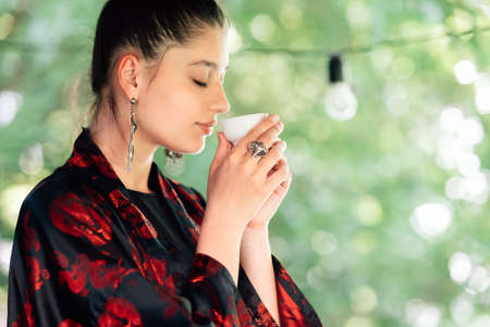 Shot of young woman drinking from tea bowlの写真素材