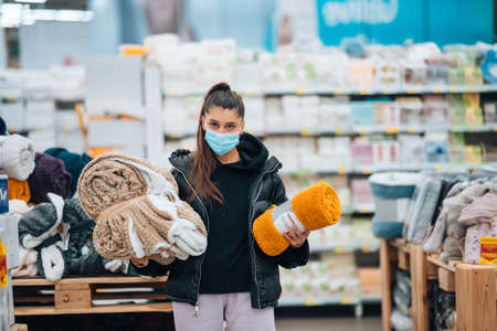 Woman with face mask buying during virus pandemic.の写真素材