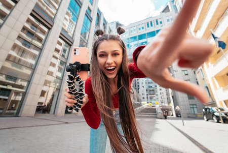 Beautiful female blogger looking at the camera on the street.