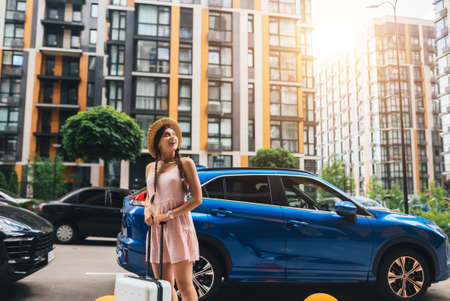 Young woman with suitcase and looks to the sideの写真素材