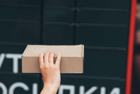 Woman holding parcel box near door, closeupの写真素材