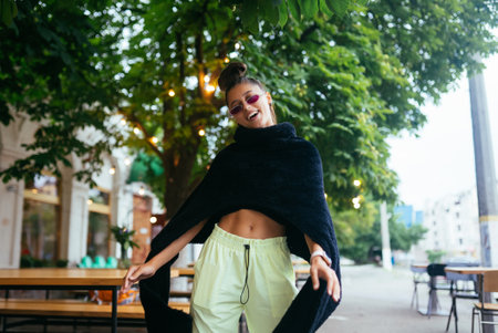 Glamorous white girl fooling around in outdoor cafe.