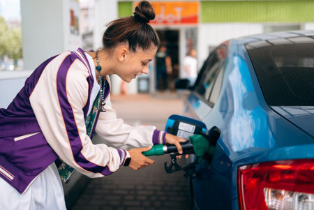 Woman filling her car with fuel at a gas station