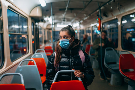 Young woman with mask traveling in the public transport.の写真素材