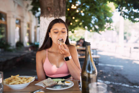 Close-up woman having breakfast cin street cafe outdoorsの写真素材