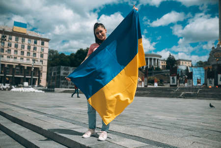 Young woman with national flag of Ukraine on the streetの写真素材