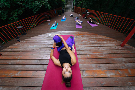 Group of young sporty people practicing yoga lesson with instructor,