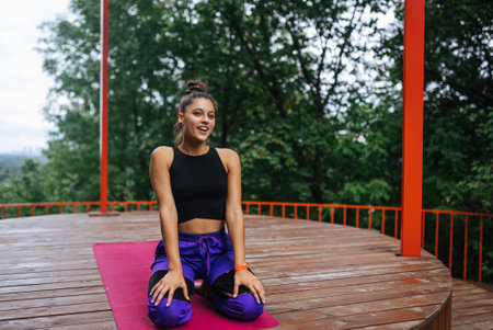 Young woman sitting on the wooden floor after training