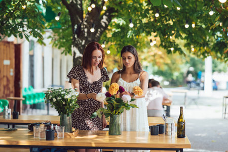 Two young women make up a beautiful festive bouquet.の写真素材