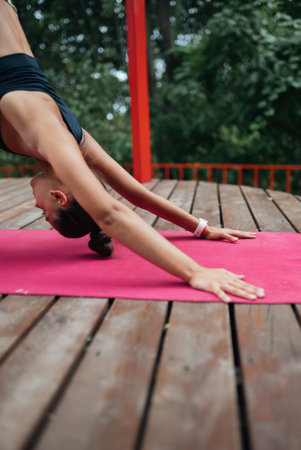 A young woman in doing yoga in the yard